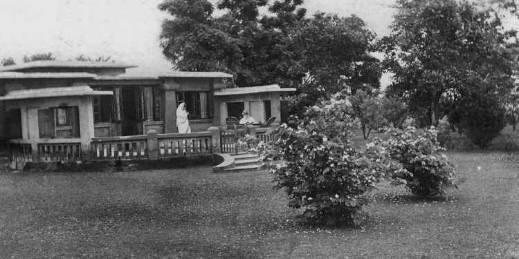 Rabindranath works on the terrace of Punashcha, Santiniketan, as Mrs Chaudhury(?) takes a photograph of him, by Shambhu Shaha. From Faces & Places of Visva-Bharati: A Collection of Photographs, by Shambhu Shaha, 2nd edn., Visva-Bharati Publishing Department, Kolkata, 2008. Rabindra Bhavana Acc. No. SS115.